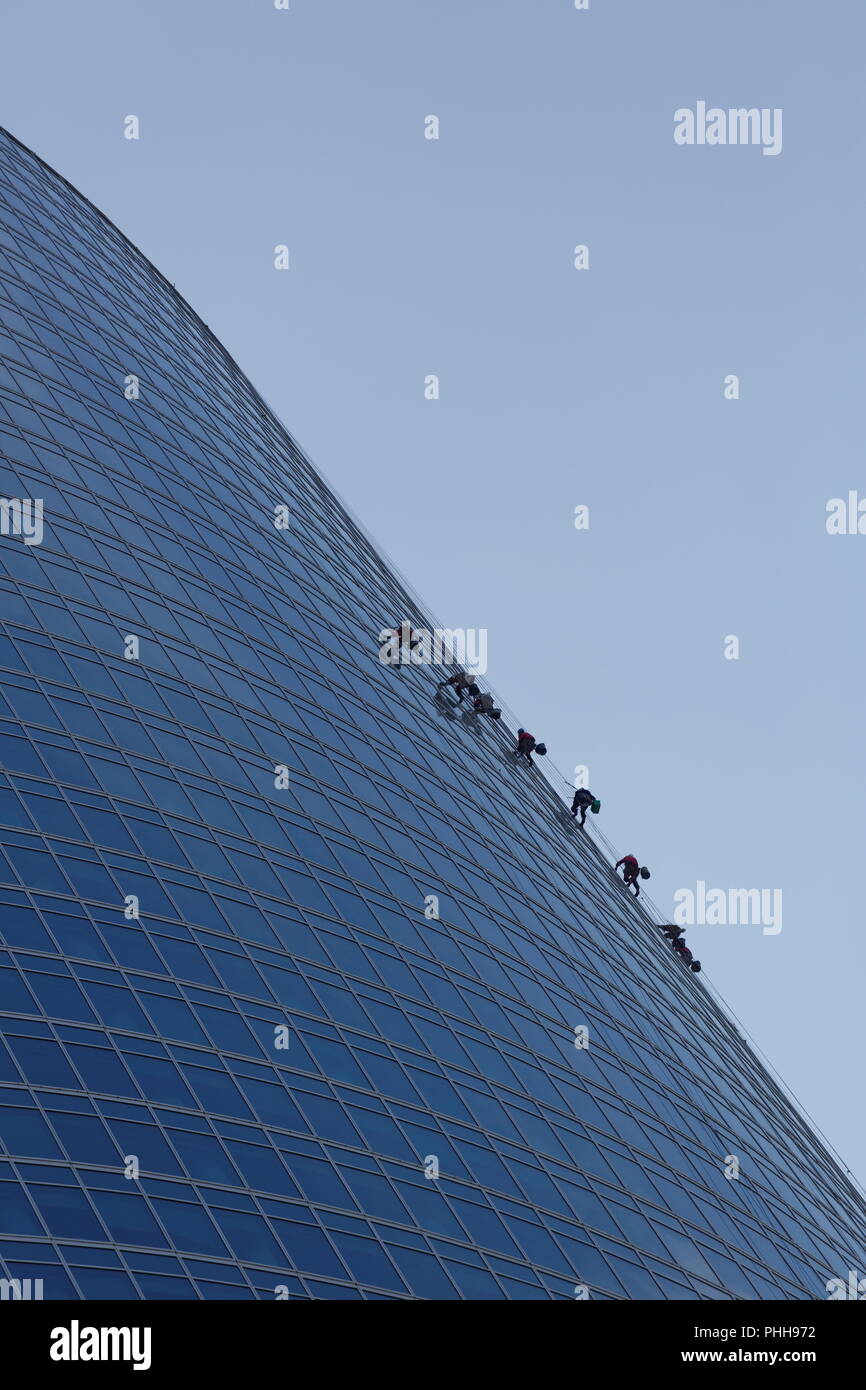 Windows washers cleaning glass facade of a high rise building Stock ...