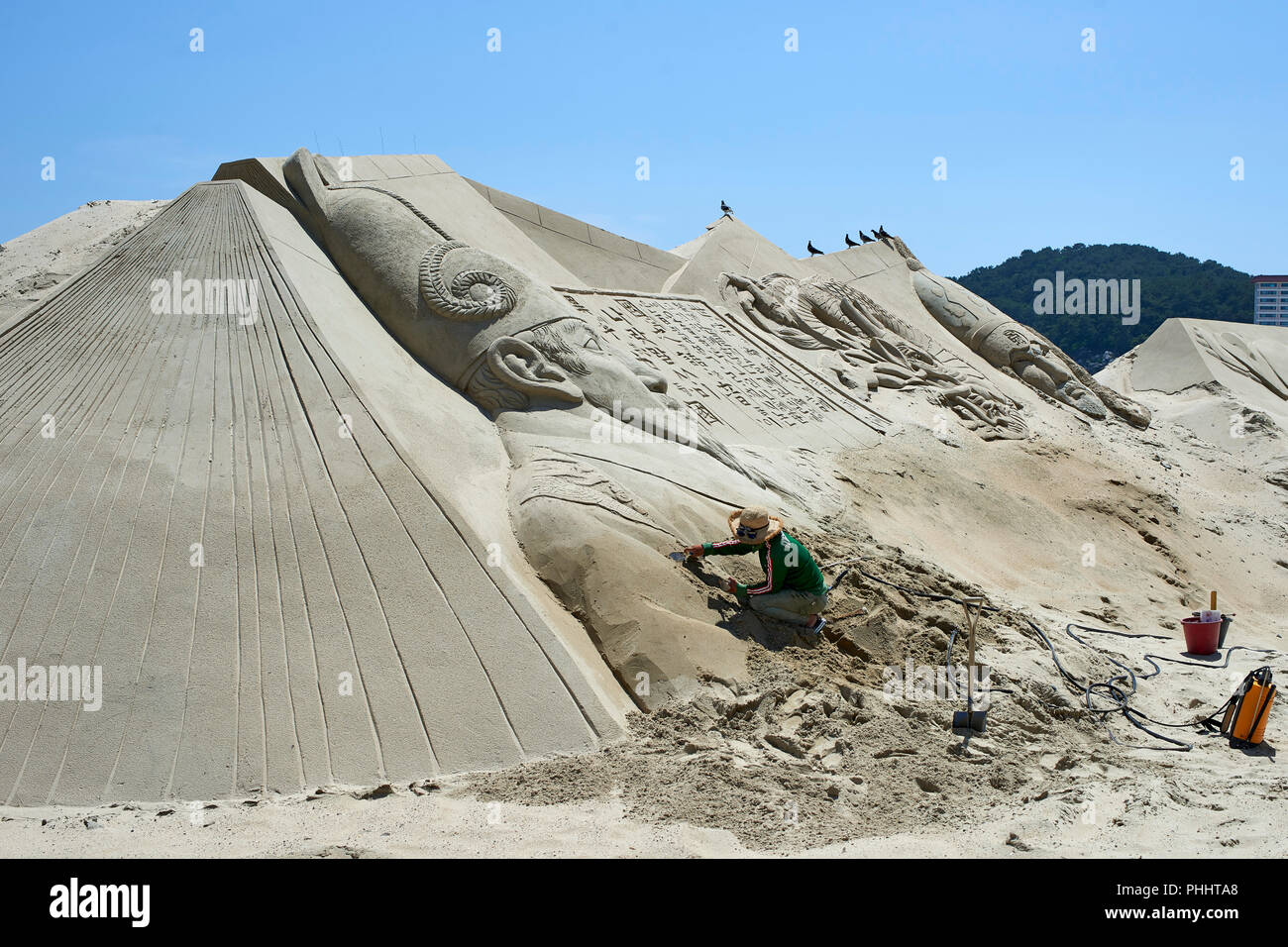 2018 Haeundae Sand Festival, Busan. Large sculpture of King Sejong. Artist carefully working on the nearly complete piece of art. Stock Photo