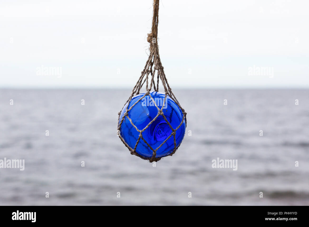 https://c8.alamy.com/comp/PHHYYD/glass-buoy-hanging-in-a-net-PHHYYD.jpg