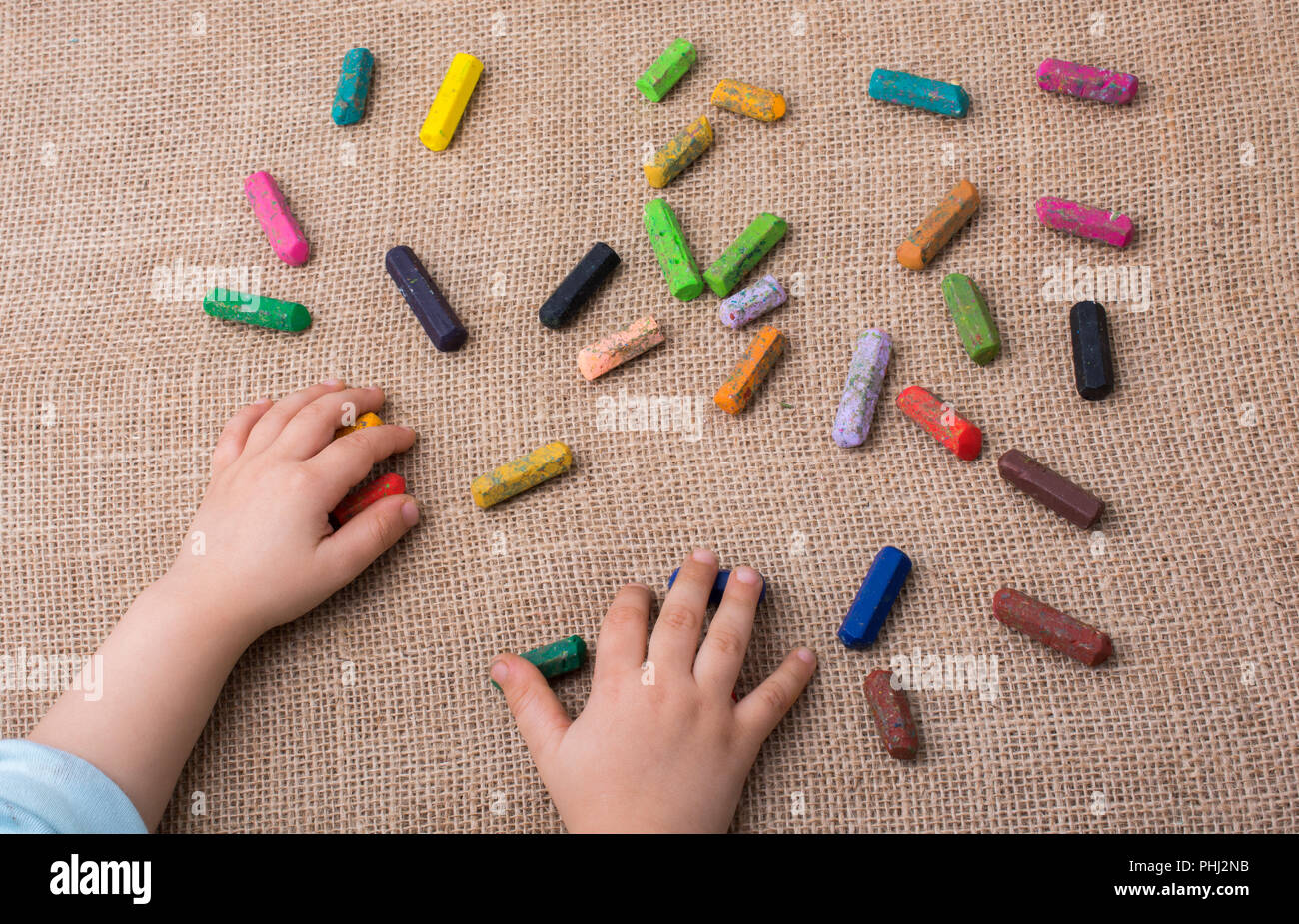 Used  color crayons and a toddlers hand Stock Photo