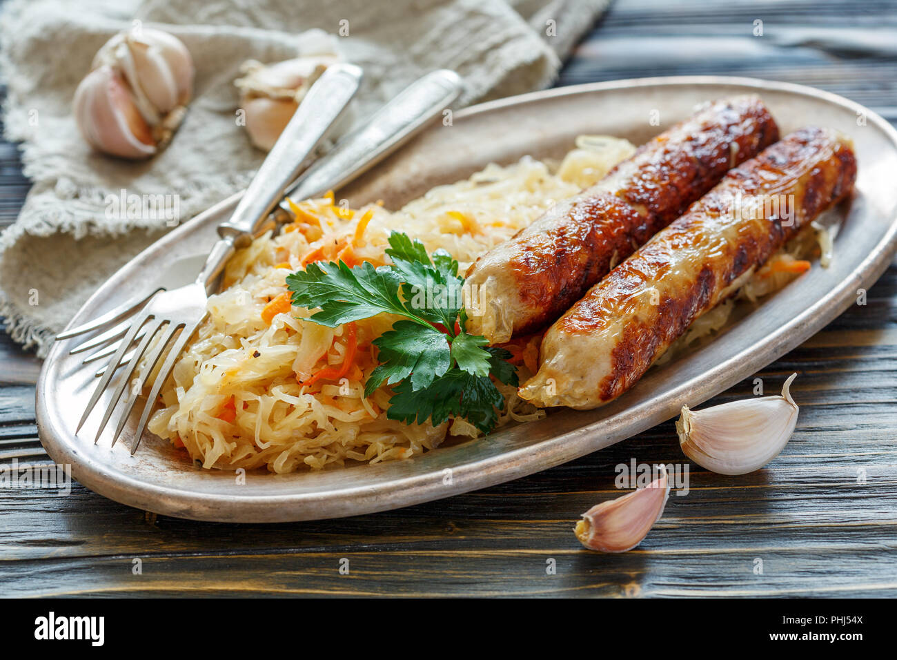 Stewed sour cabbage with sausages. Stock Photo
