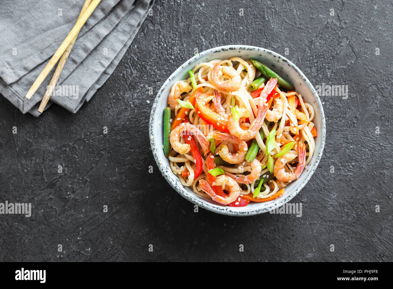 Stir fry with udon noodles, shrimps (prawns) and vegetables. Asian