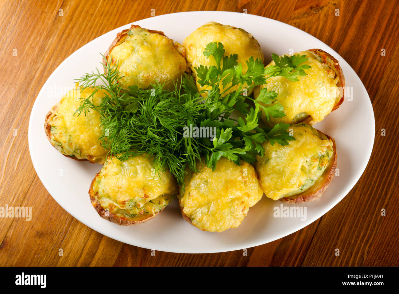 Baked potato with cheese and herbs Stock Photo