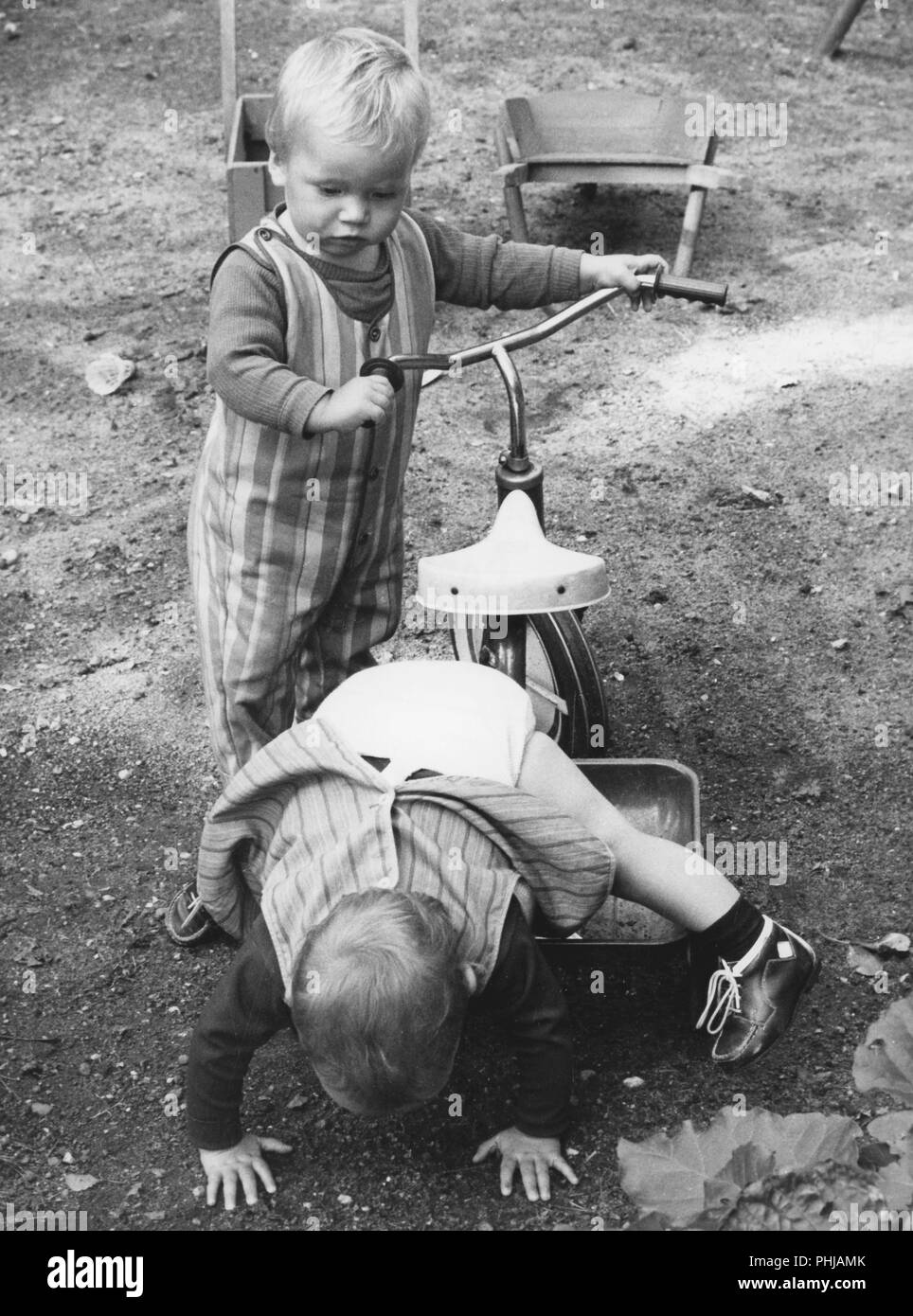 1946s children. Two boys are playing with a tricycle. Sweden 1960s Stock Photo