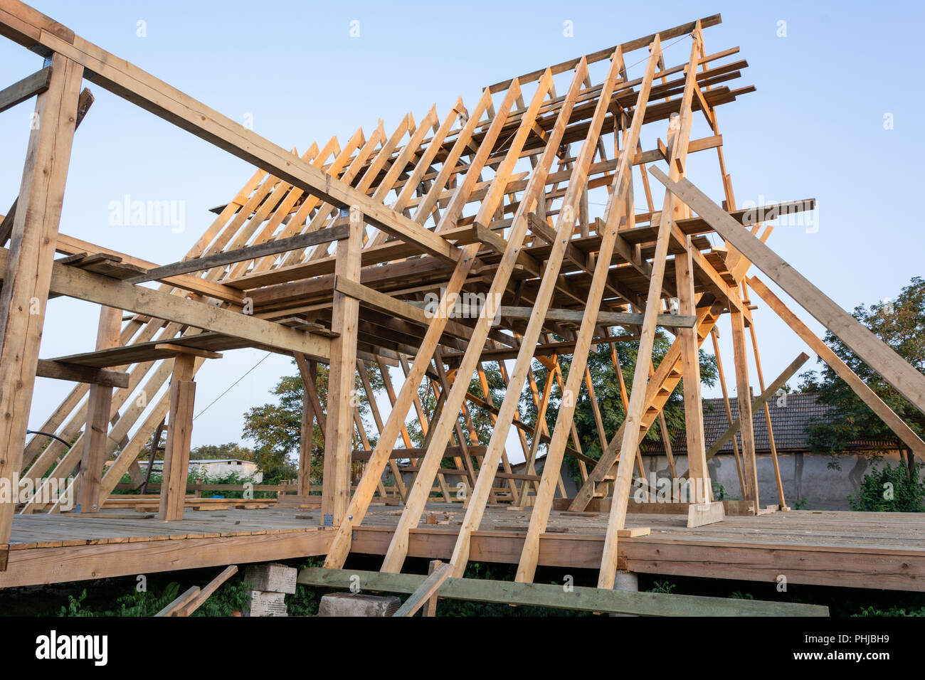 Wooden Rafters Of A New Home Under Construction At Sunset