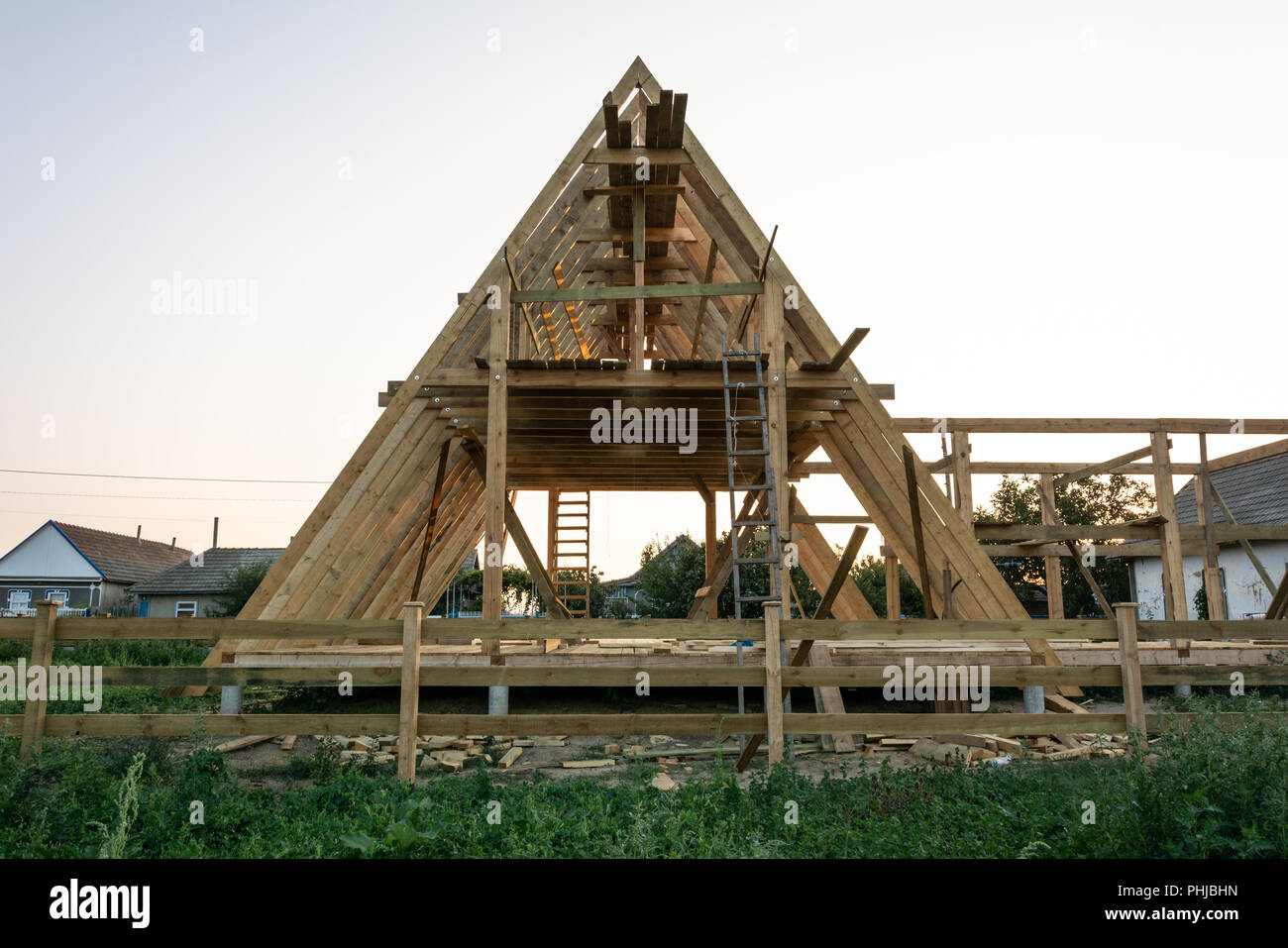 Wooden Rafters Of A New Home Under Construction At Sunset New