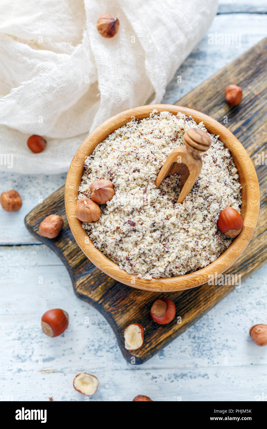 Hazelnut flour in wooden bowl and whole hazelnut Stock Photo Alamy