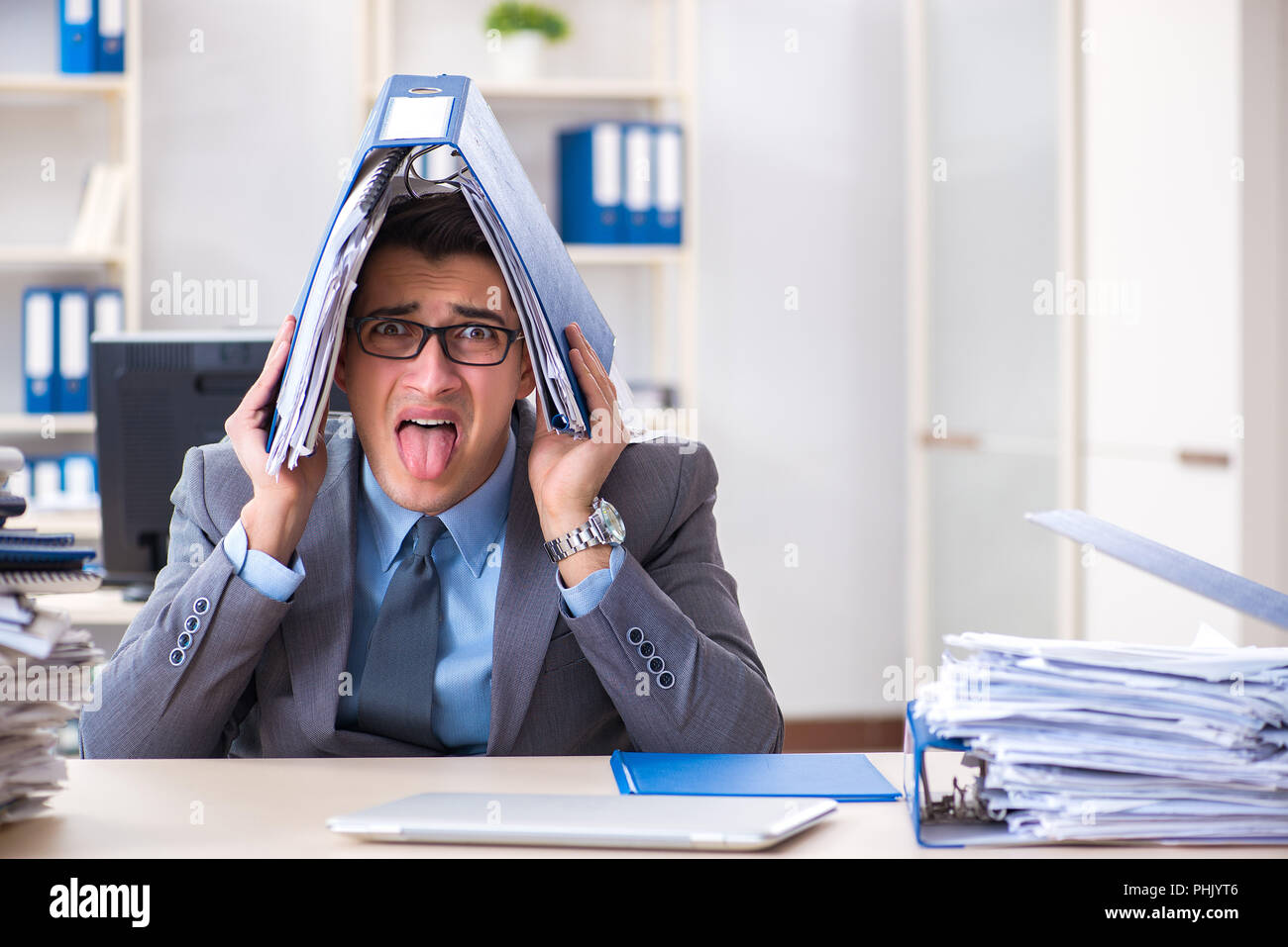 Overloaded with work employee under paperwork burden Stock Photo - Alamy