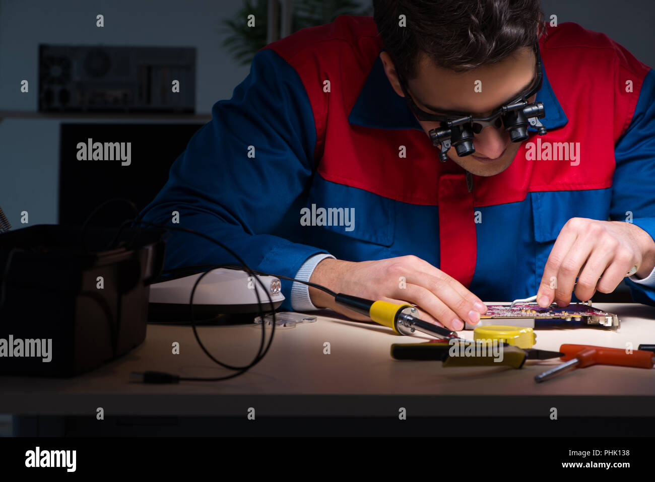 Computer specialist repairing PC late at night Stock Photo - Alamy