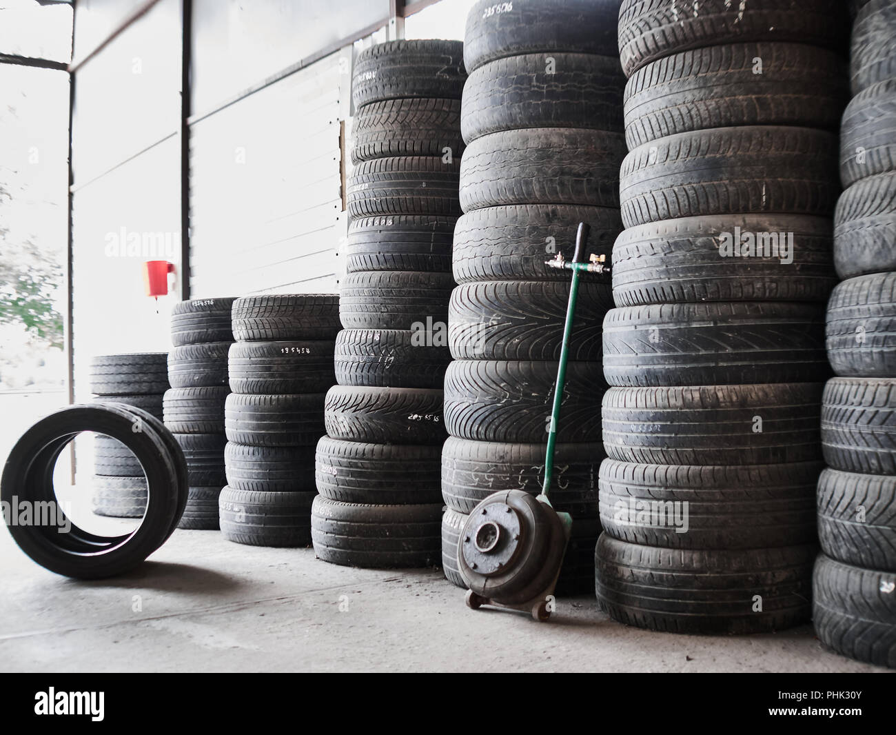 Used car tires stacked in piles at junkyard. Old wheels recycling and