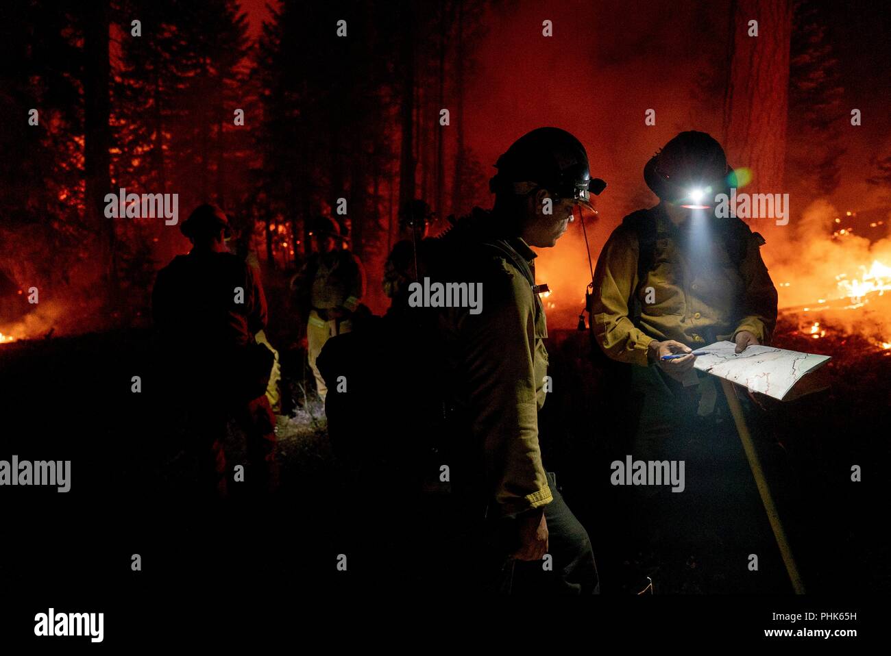 Cal State firefighters, work during a night operation to push back a