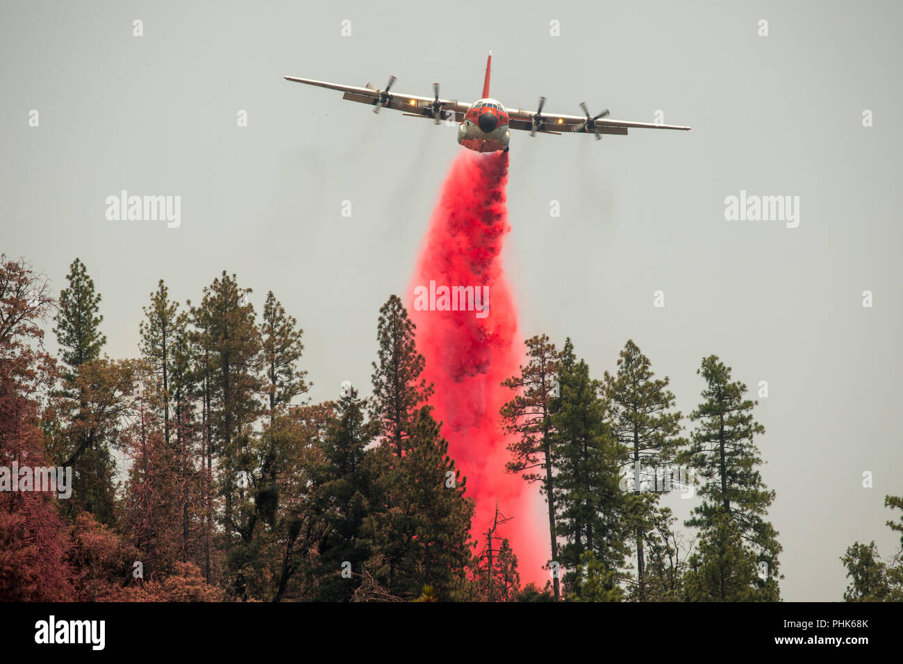 A firefighting firebombing aircraft drops a load of fire retardant on the Ferguson Fire in Sierra National Forest July 22, 2018 in Mariposa County, California. Stock Photo