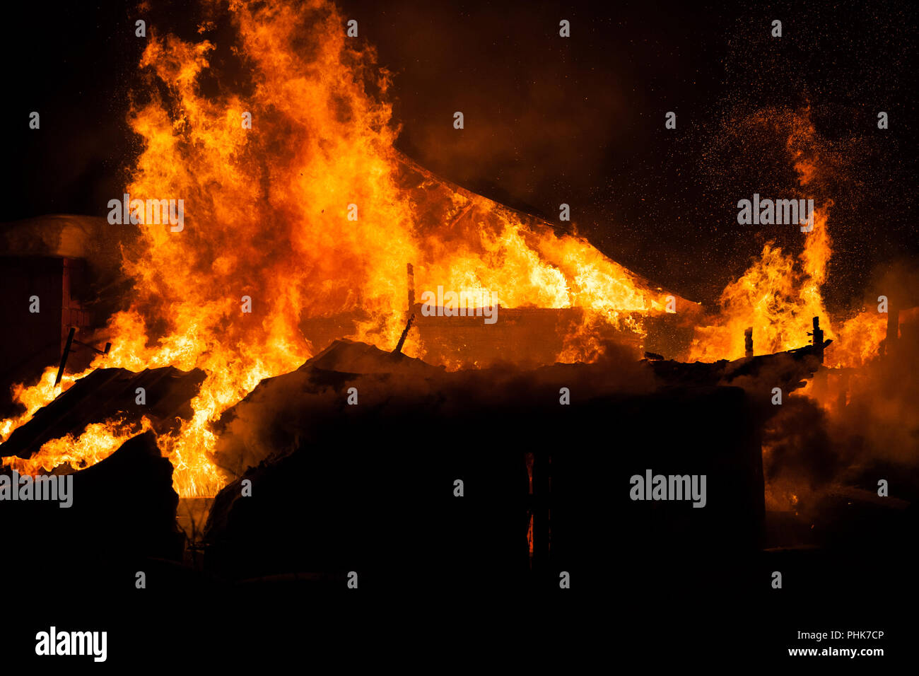 Burning fire flame on wooden house roof Stock Photo
