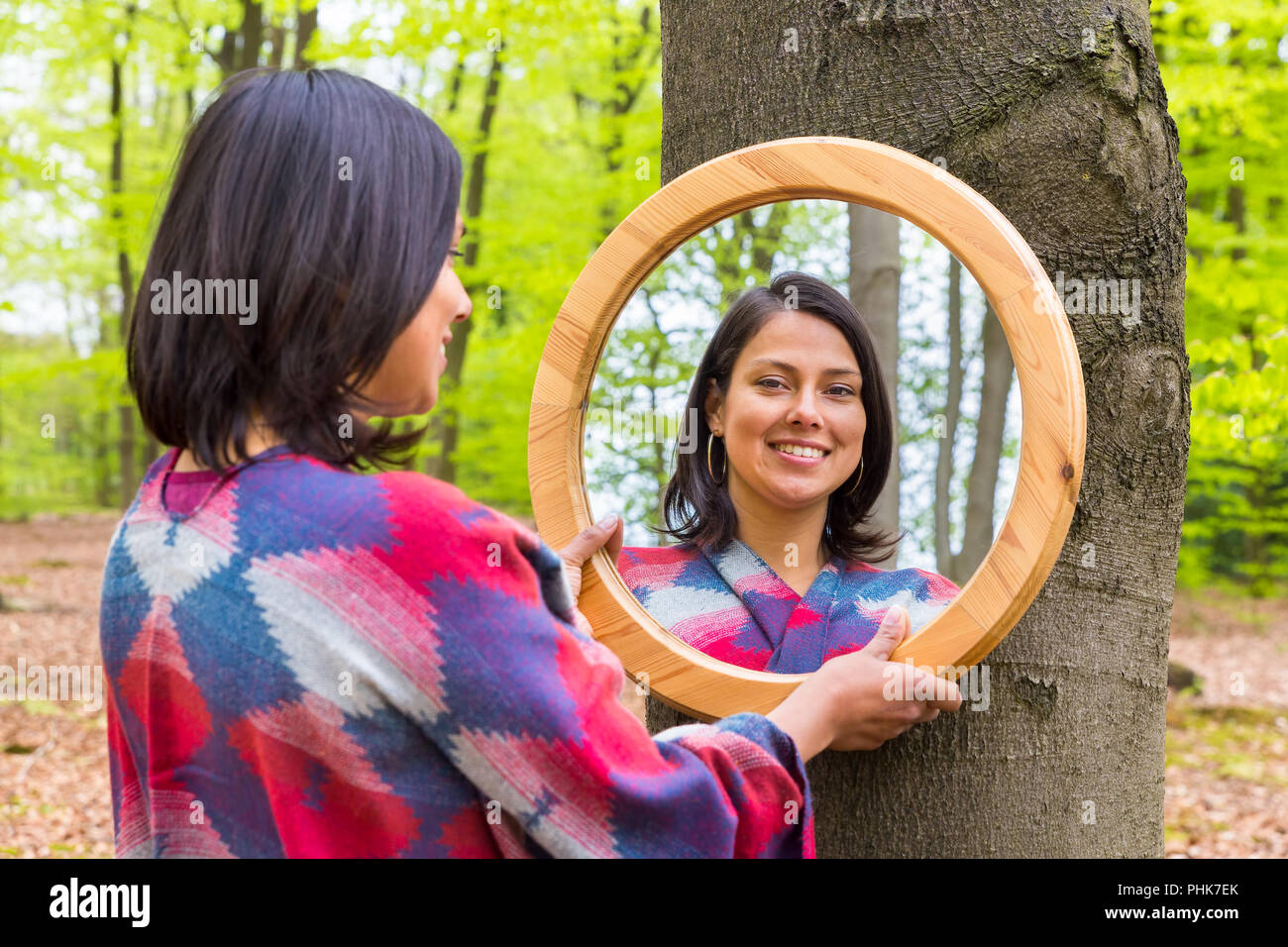 Woman looking at mirror in spring forest Stock Photo