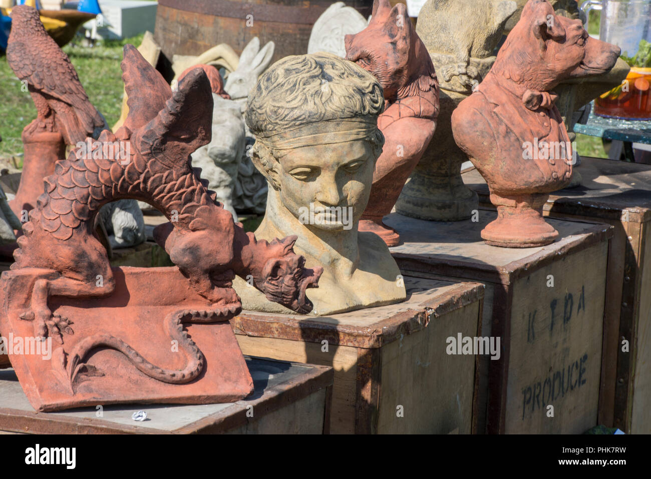 a selection of carved stone or concrete sculpted garden statues and statuary on sale at a garden