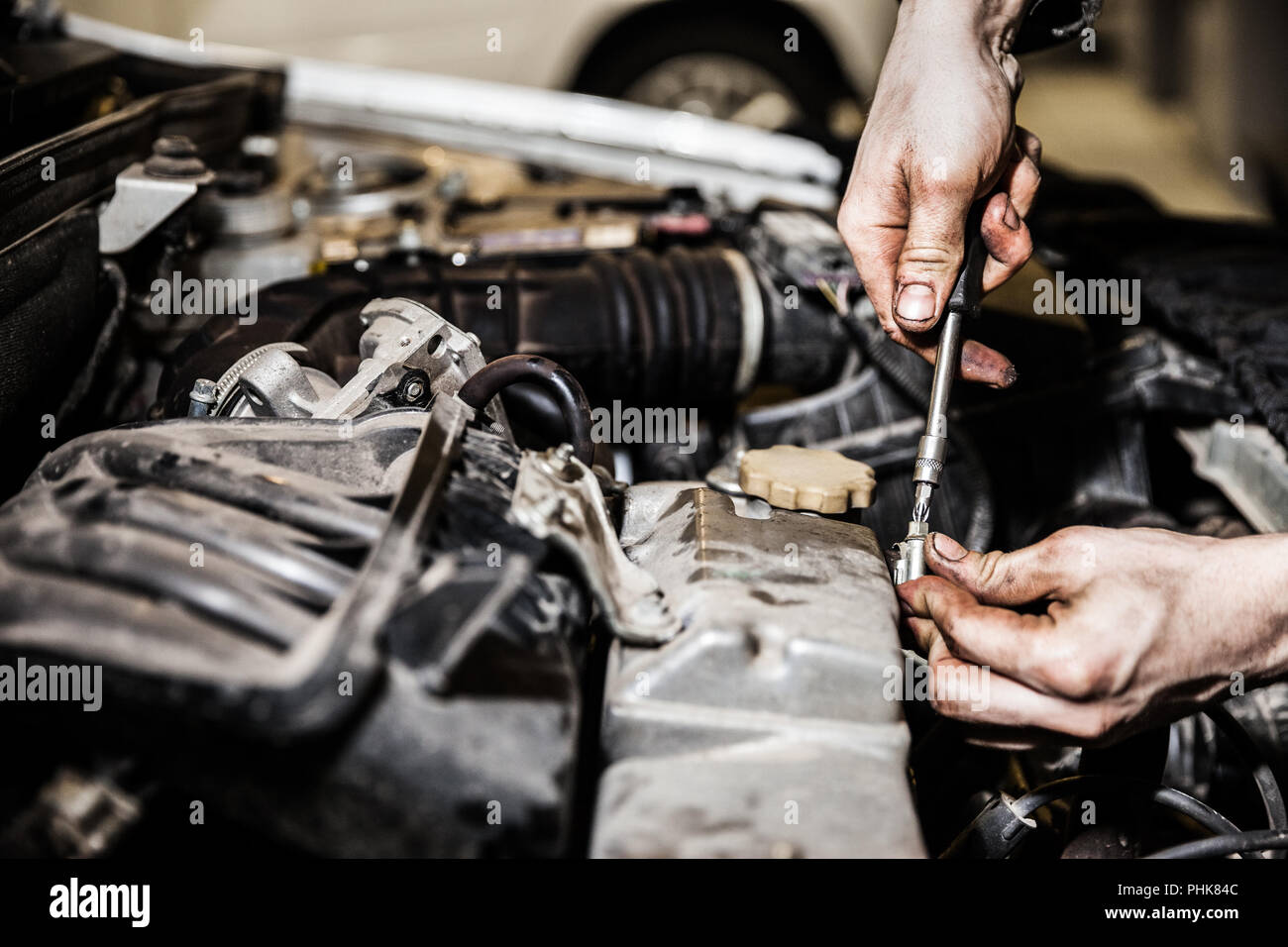 Automobile service worker or garage mechanic repairing auto car engine Stock Photo