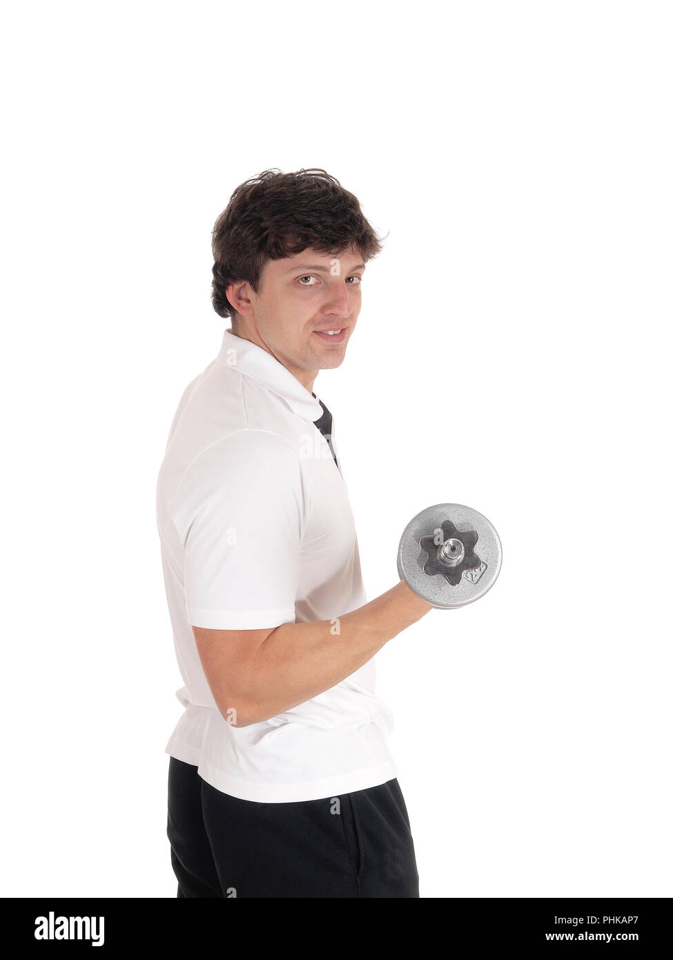 Young man standing in profile lifting dumbbell Stock Photo