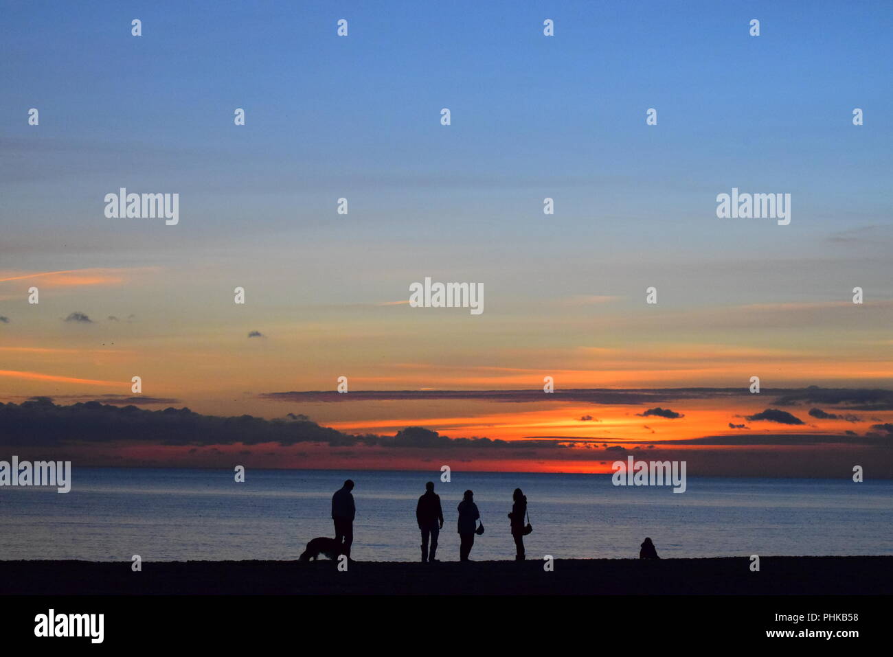 Silhouettes on the beach at sunset Stock Photo - Alamy