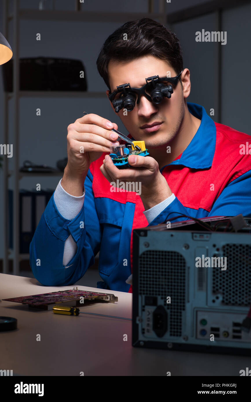 Computer specialist repairing PC late at night Stock Photo - Alamy