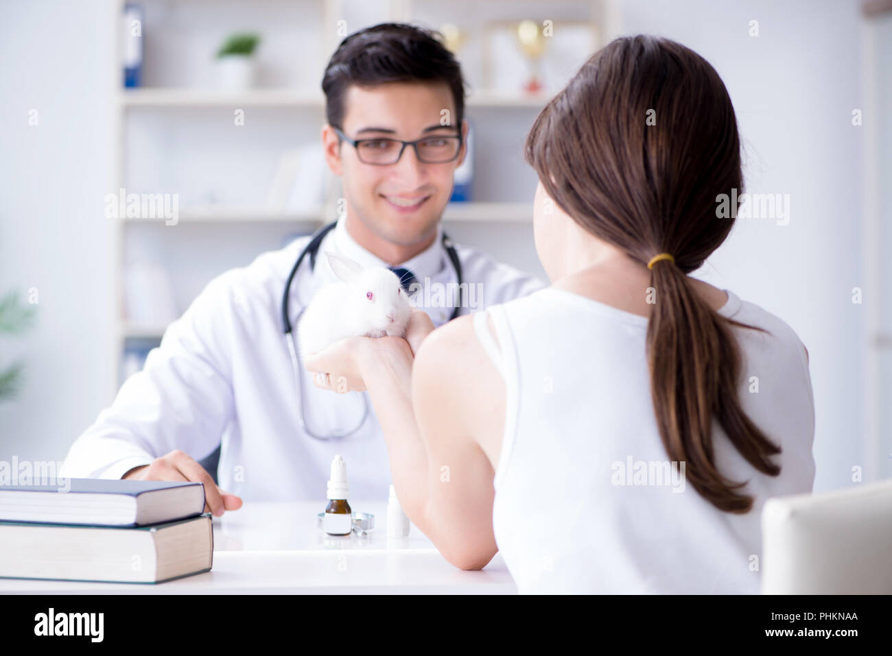 Woman with pet rabbit visiting vet doctor Stock Photo