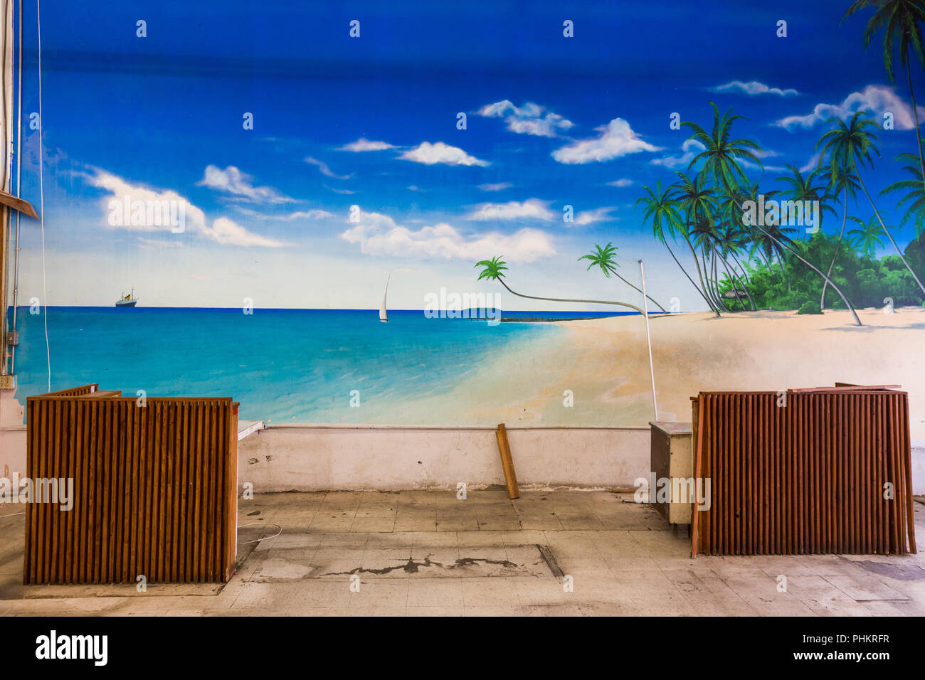 Ugly office space with large mural depicting beautiful tropical beach scene. Stock Photo