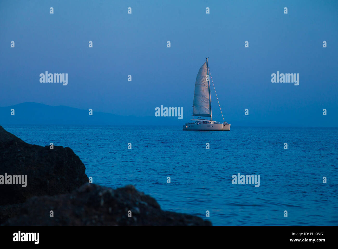 Catamaran at sea during blue hour in the morning Stock Photo - Alamy