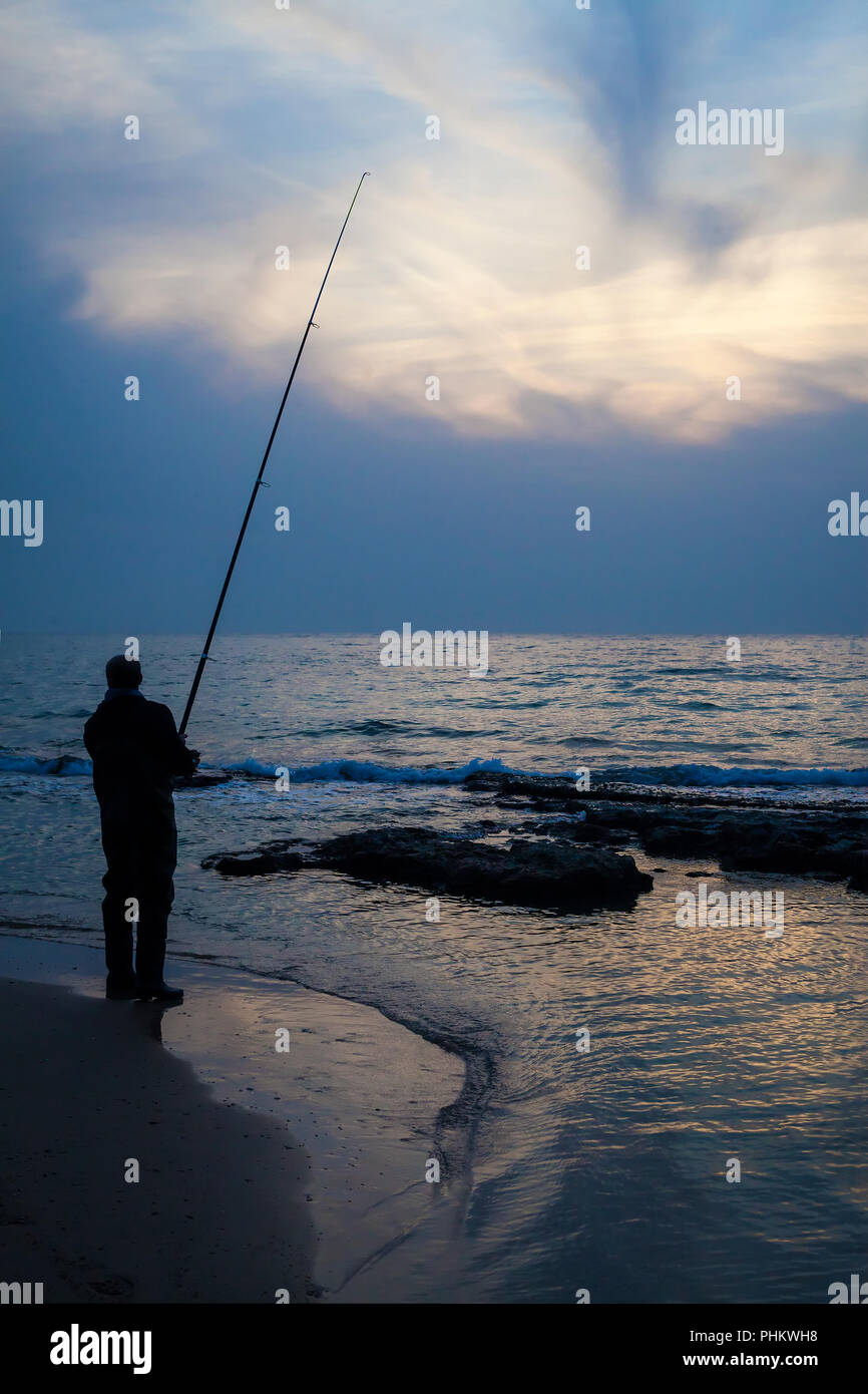 Fisherman fishing at sea in the early morning Stock Photo Alamy