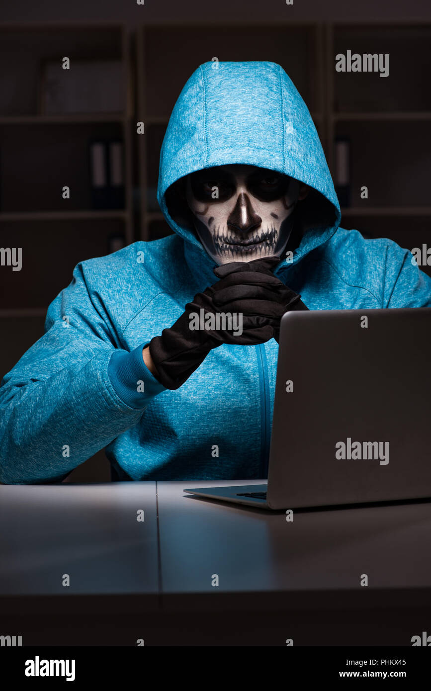 Scary hacker hacking security firewall late in office Stock Photo - Alamy