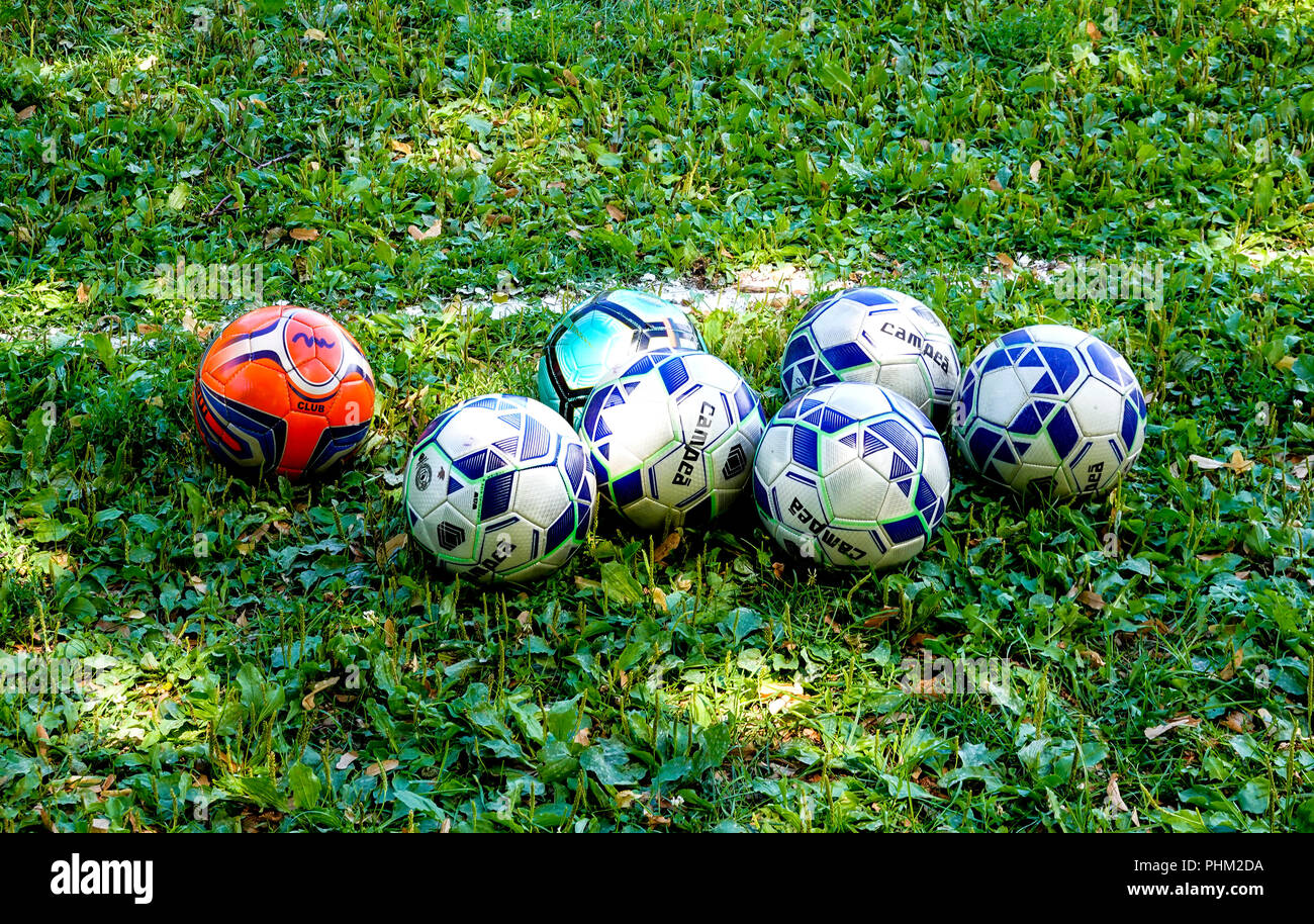 Soccer balls on green waiting for the school teams to arrive Stock Photo