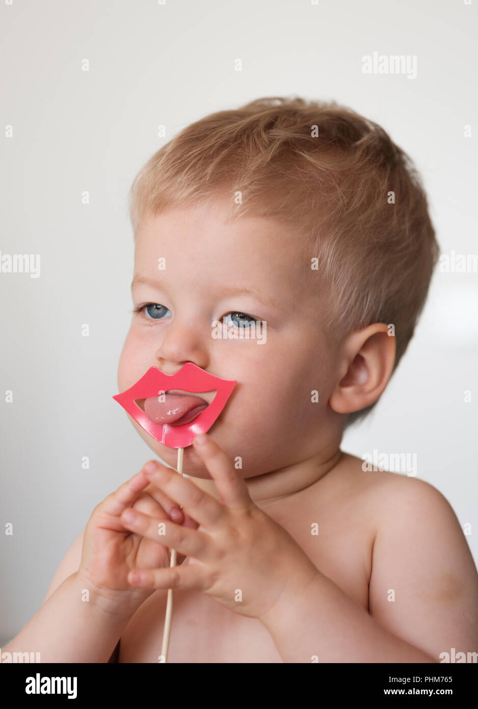 Baby boy with paper lips on a stick Stock Photo Alamy