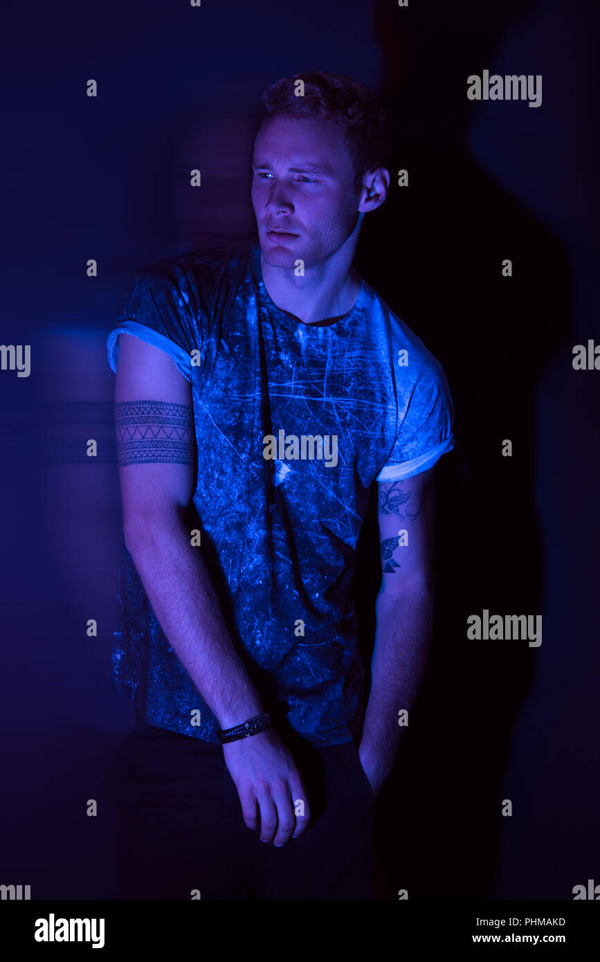 A high fashion futuristic male portrait shoot in a studio with blue light gel. Stock Photo