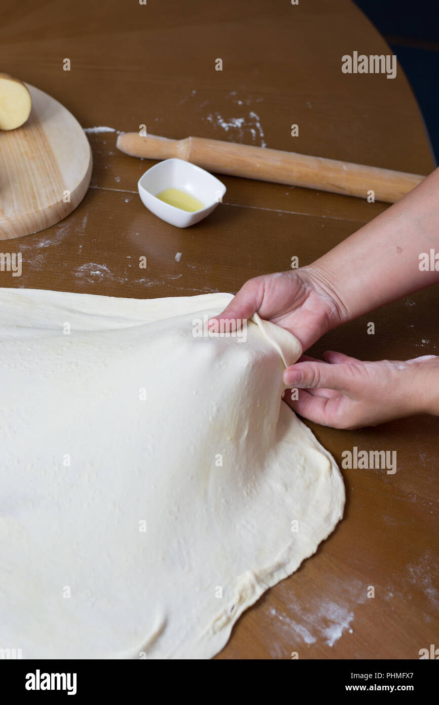 Woman making dough with meat at home Stock Photo