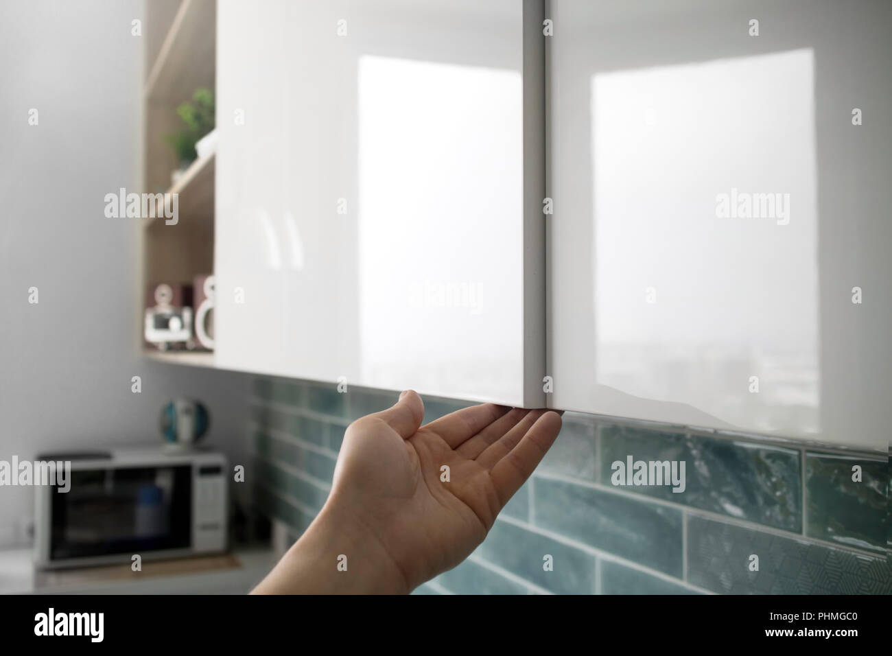 male hand open the cupboard doors in the kitchen Stock Photo Alamy