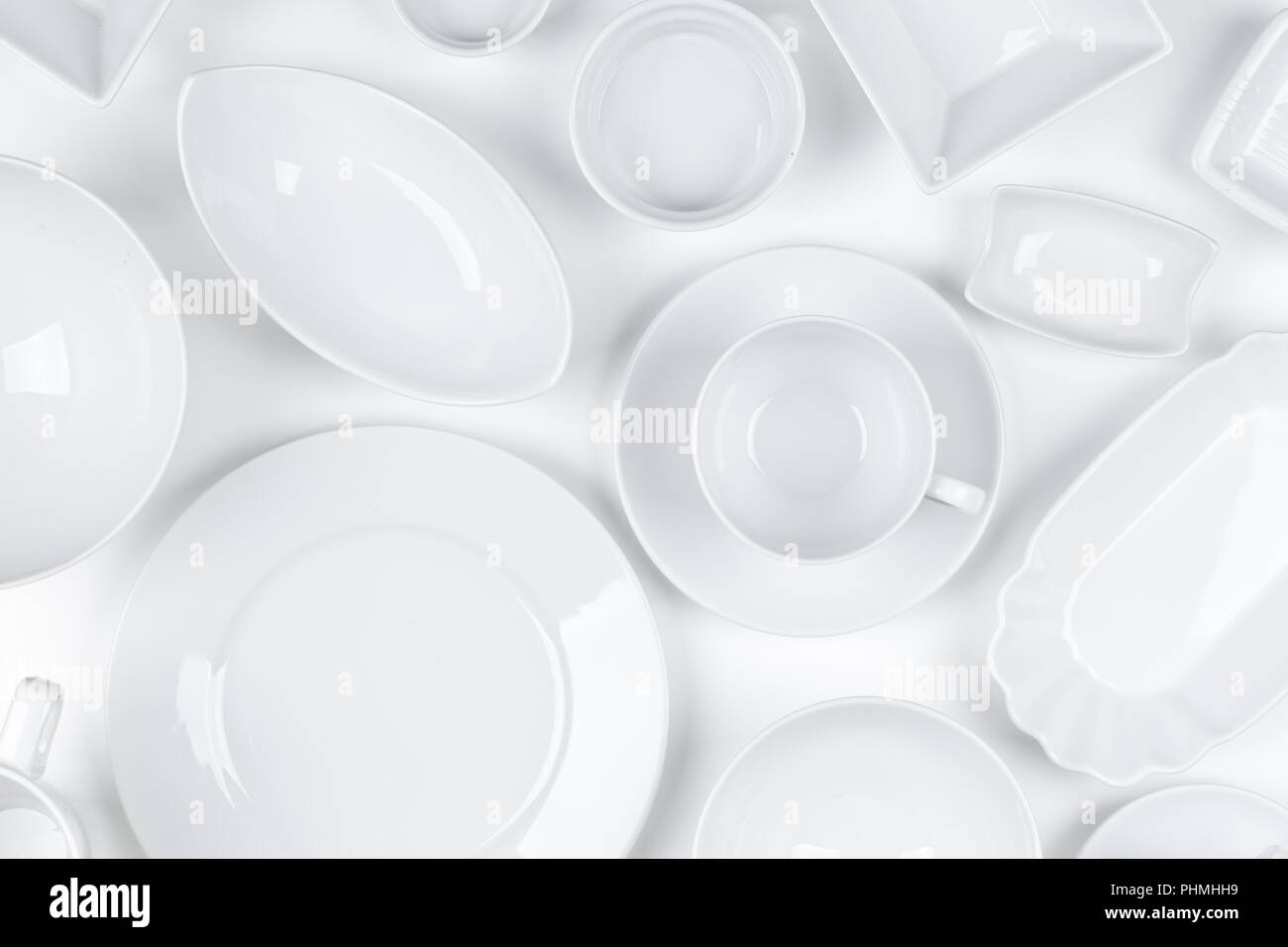Empty, clean white assorted dishware with plates, cups and bowls white background Stock Photo
