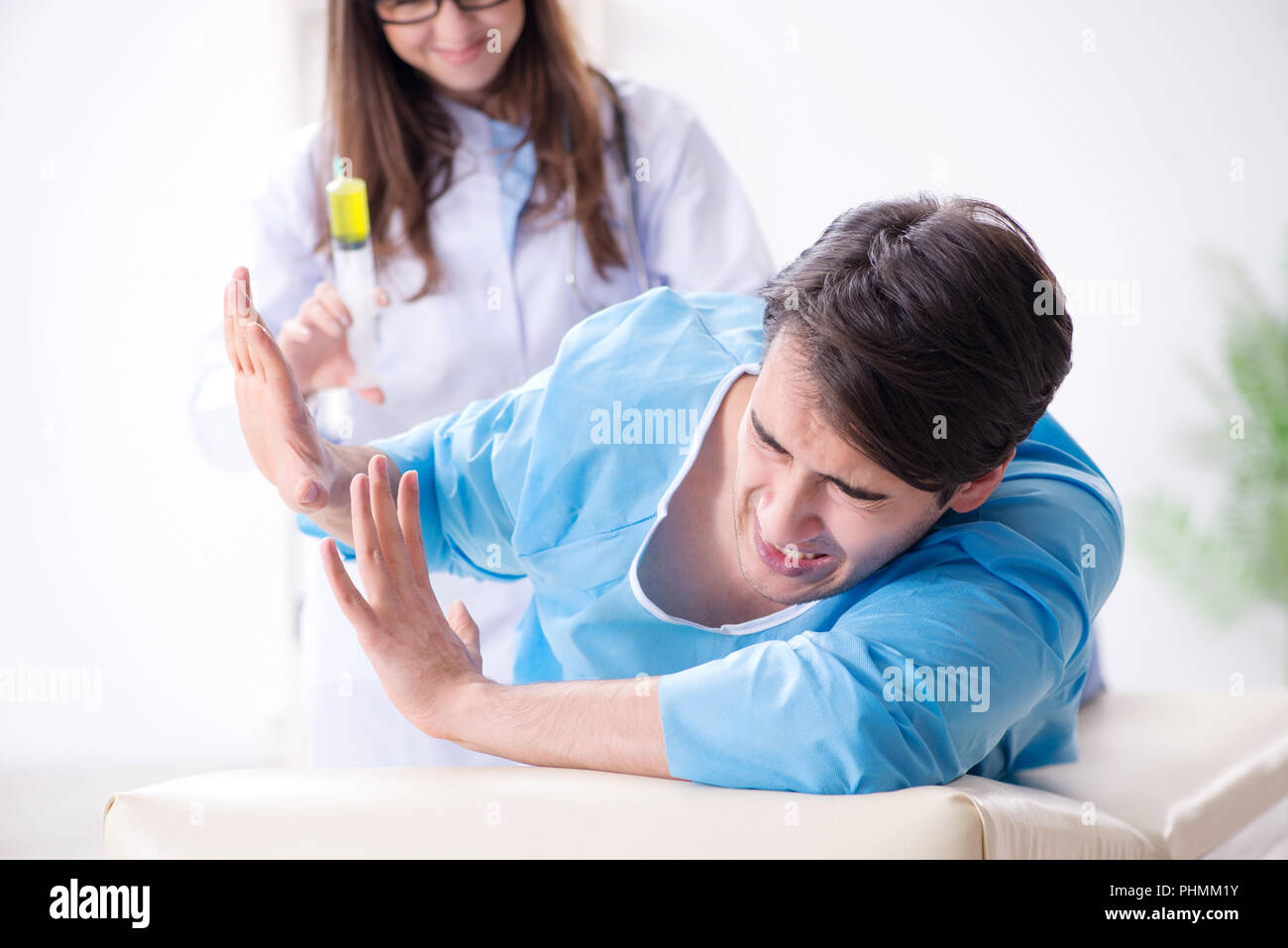 Funny man getting ready for buttocks syringe shot Stock Photo - Alamy