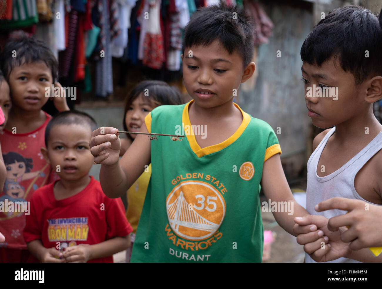 Filipino children partaking in the popular game of spider fighting. Stock Photo