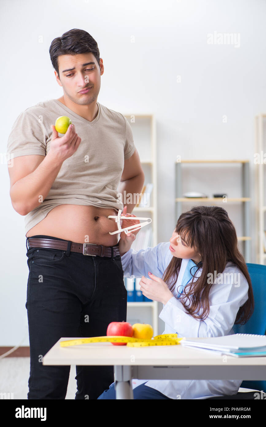 Doctor dietician giving advices to fat overweight patient Stock Photo