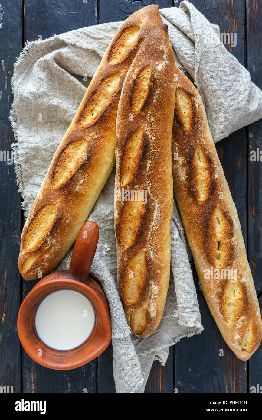 Artisanal loaves baguettes and a pitcher of milk. Stock Photo
