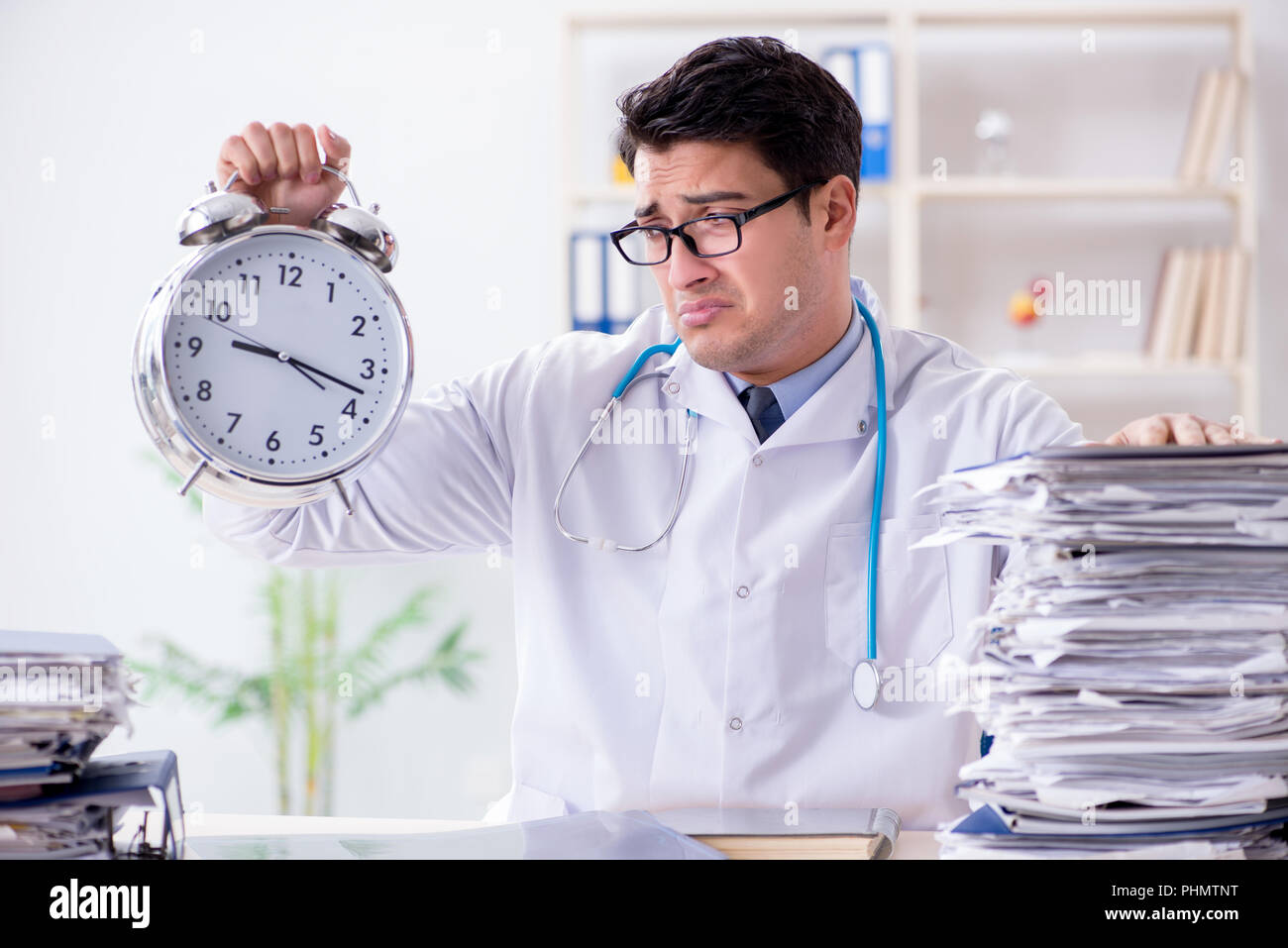 Doctor with alarm clock in urgent check-up concept Stock Photo - Alamy