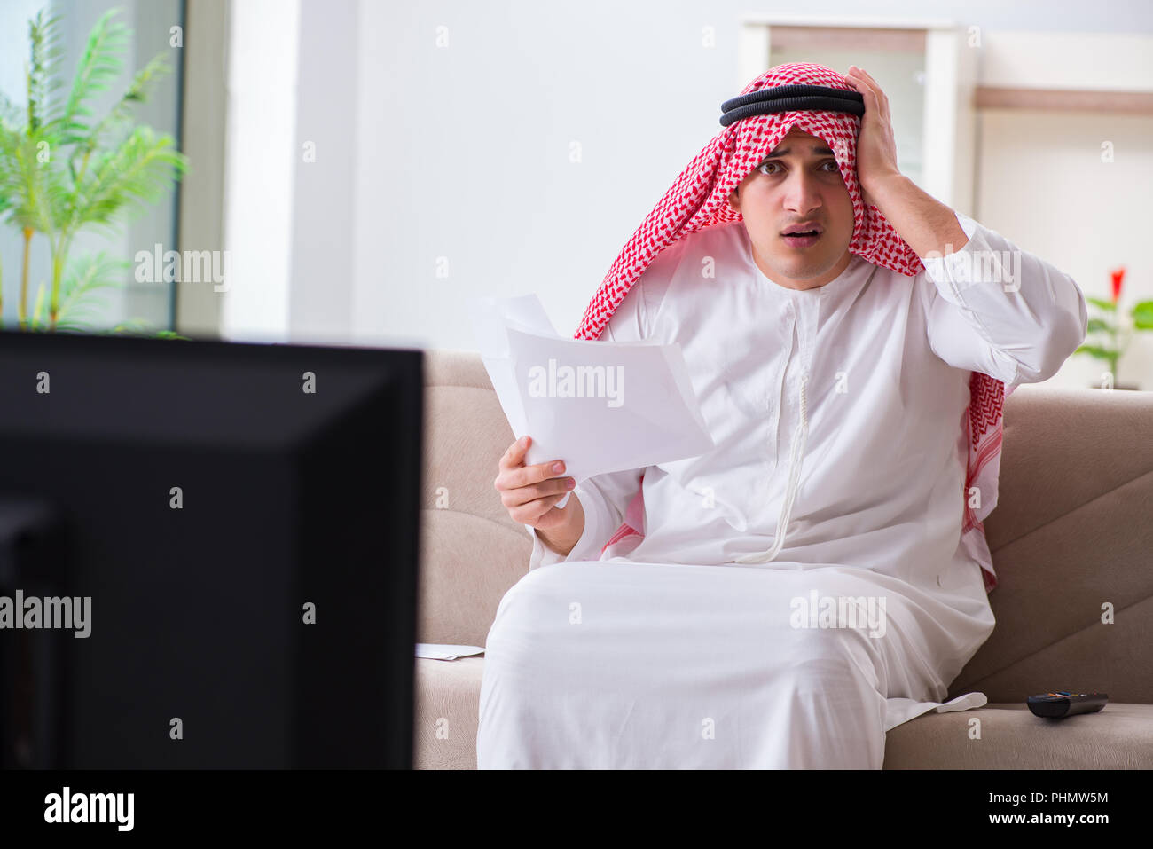 Arab businessman watching tv at home Stock Photo