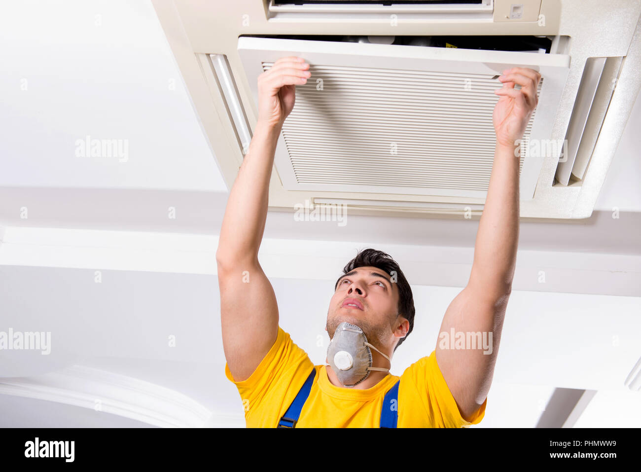 Repairman Repairing Ceiling Air Conditioning Unit Stock Photo