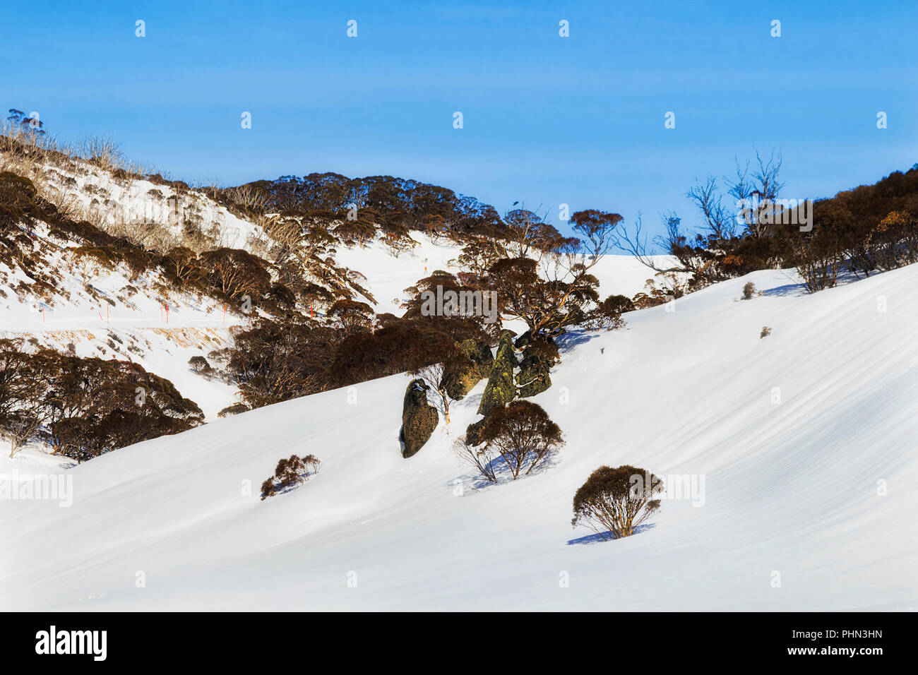 Snow covered slopes of SNowy mountains surrounding Perisher valley during winter season in popular skiing and snowboarding resort, good for cross-coun Stock Photo