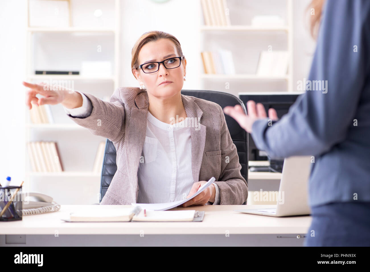 Angry boss dismissing employee for bad underperformance Stock Photo