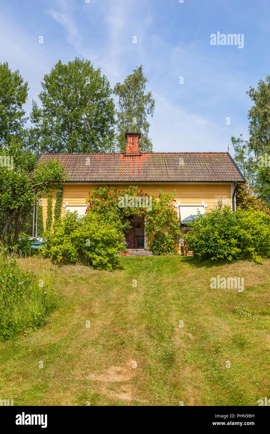 Summer cottage with red climbing roses Stock Photo
