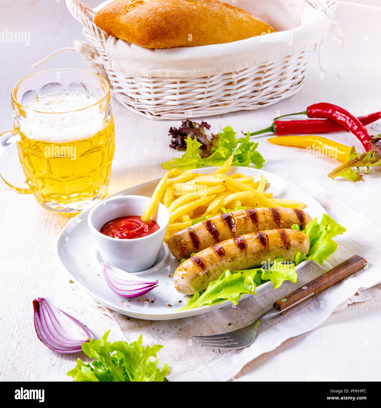grilled bratwurst with chips and cold beer Stock Photo - Alamy