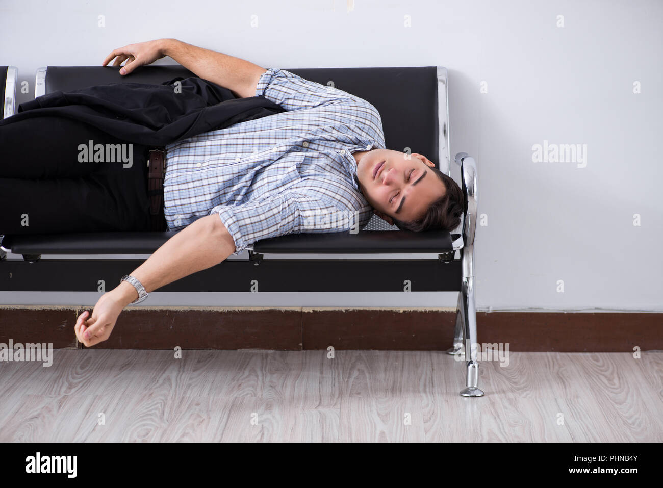 Man sleeping on the chairs in airport Stock Photo Alamy