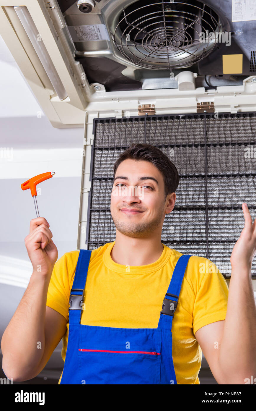 Repairman repairing ceiling air conditioning unit Stock Photo Alamy