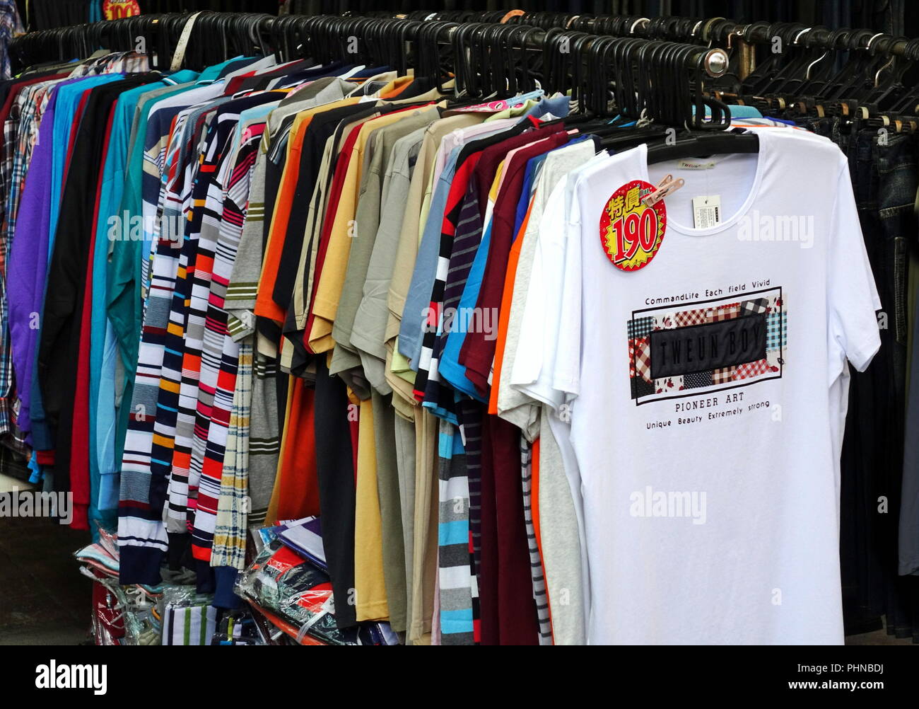 KAOHSIUNG, TAIWAN -- AUGUST 18, 2018: A street vendor at the Nan Hua tourist market sells cheap t-shirts. Stock Photo