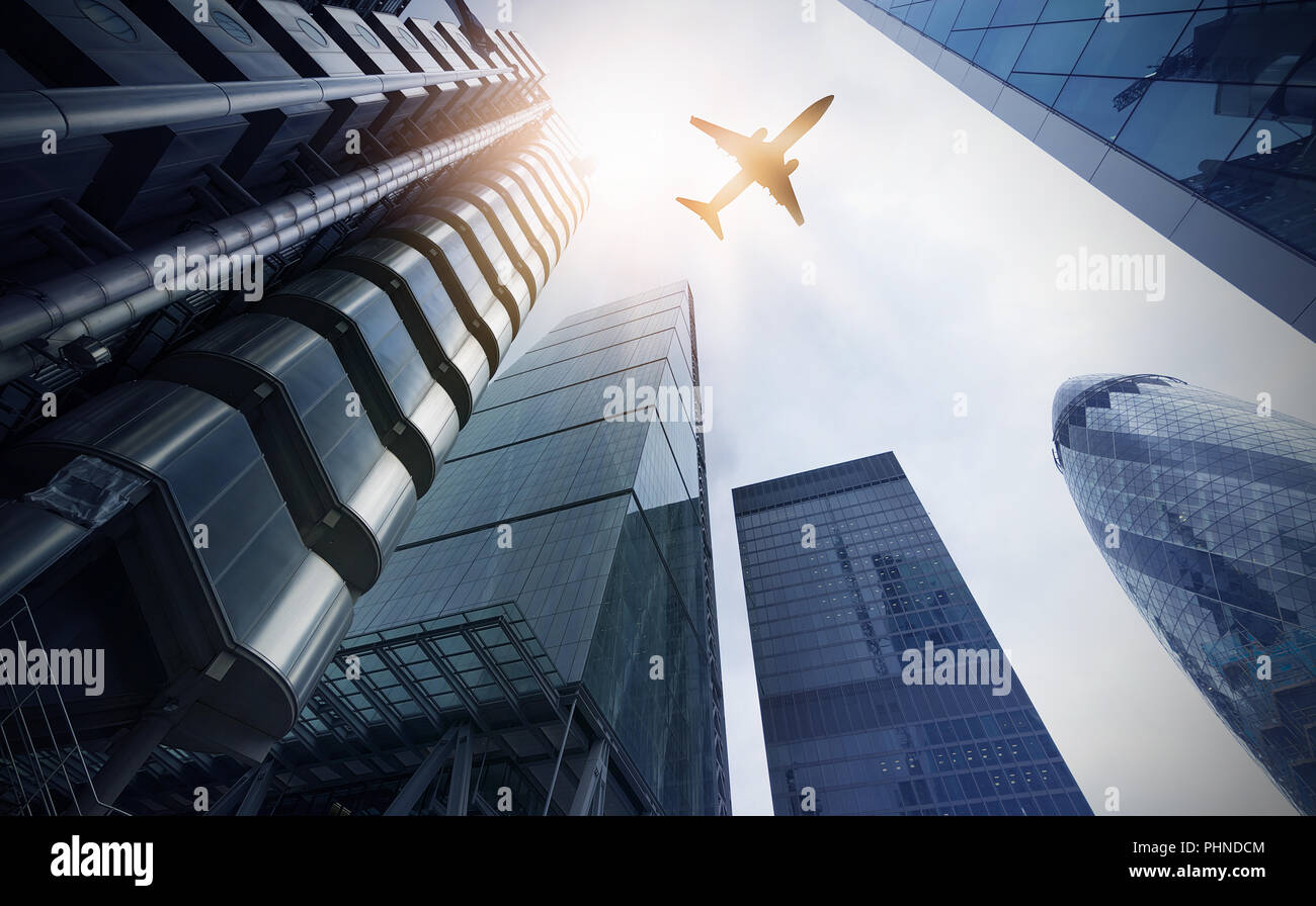 plane over multiple office towers Stock Photo