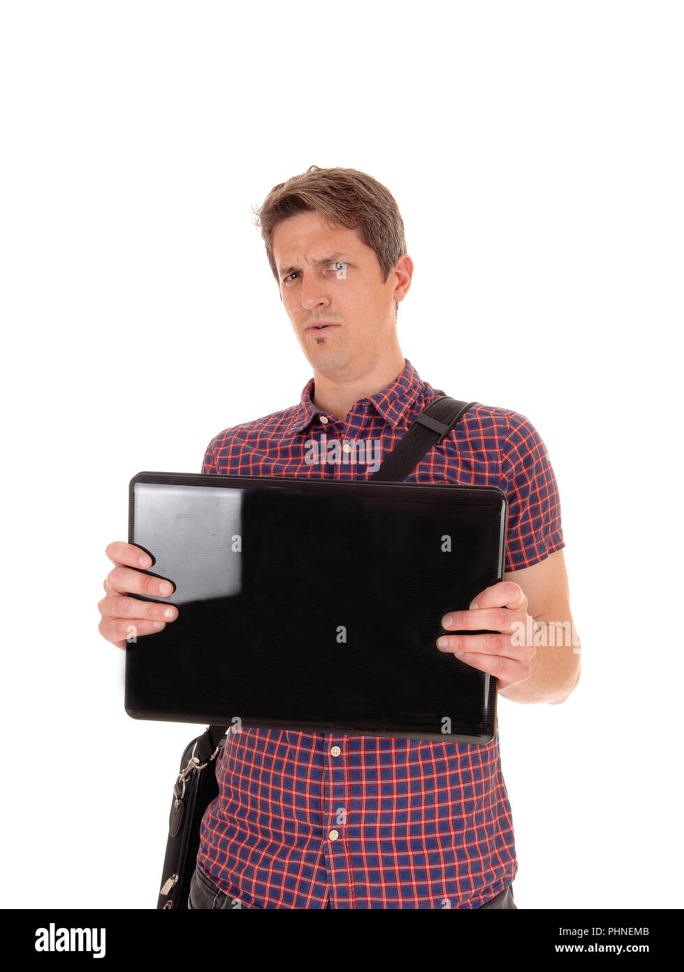 Puzzled man holding up his laptop to see Stock Photo